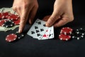 The player bets on a winning combination of three of a kind or a set in a poker game on a black table with chips and money in a Royalty Free Stock Photo