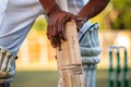 player checking wooden bat for imperfections