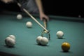 Billiard player striking a ball with cue stick using the rest Royalty Free Stock Photo