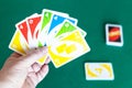 Player holds UNO game cards over green table Royalty Free Stock Photo