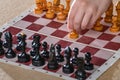 The player holds a white pawn in his hand and starts the game of