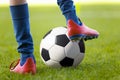 Player Kick a Soccer Ball on a Grass Pitch. The Perfect Football Kick. Young Footballer in Soccer Gear