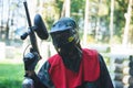 Player in paintball in gear and a game marker with his hands up leaves the court after hitting. Royalty Free Stock Photo