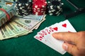 Player points with his finger at a winning straight flush combination in a poker game on a table with chips and money in a casino Royalty Free Stock Photo