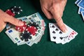 Player points with his finger at a winning two pairs combination in a poker game on a table with chips and money in a casino Royalty Free Stock Photo