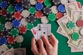 A player in a poker casino shows a pair of aces against the background of chips and money of dollars. Victory, success. Gaming Royalty Free Stock Photo