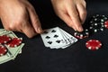 Player puts playing cards with straight flush winning combination in poker game on black table with chips and money in club Royalty Free Stock Photo