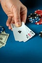 The player puts playing cards with a winning combination of three of a kind or set in a game of poker on a blue table with chips Royalty Free Stock Photo