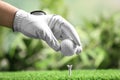 Player putting golf ball on tee against blurred background Royalty Free Stock Photo