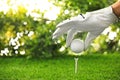 Player putting golf ball on tee at green course Royalty Free Stock Photo