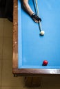 Player\'s arm holding cue above pool table. The player is about to strike the white ball Royalty Free Stock Photo