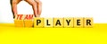 Player or teamplayer symbol. Businessman turns wooden cubes and changes concept words Player to Teamplayer. Beautiful yellow table Royalty Free Stock Photo