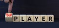 Player or teamplayer symbol. Turned wooden cubes and changed concept words Player to Teamplayer. Beautiful grey table grey Royalty Free Stock Photo