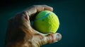 A players hand gripping the tennis ball tightly before a powerful serve