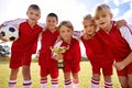 Players, soccer team and children with cup, victory and girls with boys, support or proud. Achievement, sports and Royalty Free Stock Photo