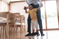 Playful African American Dad and his cute little son walking on the floor Royalty Free Stock Photo