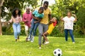 Playful african american multi-generational family playing soccer together in backyard on weekend Royalty Free Stock Photo