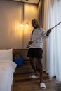 Playful African man in casual clothes Clean the dust or dirtiness of the room happily and have fun cleaning.