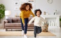 Playful afro american family mother and son running and playing in living room at home Royalty Free Stock Photo