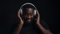 Playful afro guy wearing headphones indoors. Man listening music in studio Royalty Free Stock Photo