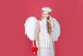 Playful angelic little girl. Little blonde angel with white wings holds gift. Cute angel child girl with angels wings Royalty Free Stock Photo