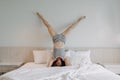 Playful woman is doing upside down pose on the bed. Royalty Free Stock Photo