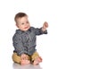 Baby boy raises his hand and lets saliva from his mouth on a white background