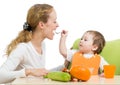 Playful baby spoon feeding his mother