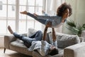 Playful biracial father and small daughter have fun at home