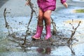 Child outdoor jump into puddle in boot after rain