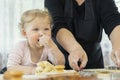 Playful child steals and eats raw dough, fun cooking, enjoy baking, lifestyle