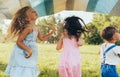 Playful children playing under the blanket, jumping and dancing together. Happy little boy and little girls enjoying summer day in Royalty Free Stock Photo