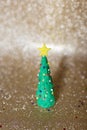 Playful clay christmas concept. Colorful handmade miniature Christmas tree in gold background