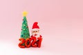 Playful clay christmas concept. Colorful handmade miniature Christmas tree and Santa Claus with mask on pink background. 2021 new