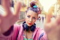 Playful cool funky hipster young girl with headphones and crazy hair taking selfie on street Royalty Free Stock Photo