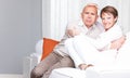 Playful couple relaxing at home as man sticks out his tongue