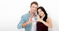 Playful couple fooling on valentine day. Beautiful young lovers are joining and smiling, making a heart frame from their