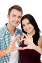 Playful couple fooling on valentine day. Beautiful young lovers are joining and smiling, making a heart frame from their hands