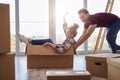 Playful couple having fun with boxes during move house Royalty Free Stock Photo