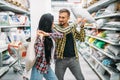 Playful couple in supermarket, pillow fight