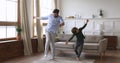 Playful crazy daddy and cute kid son having fun dancing