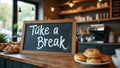 Playful cursive Take a Break on caf chalkboard pastries coffee on counter Royalty Free Stock Photo