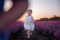 Playful cute boy girl are playing in rows of lavender purple field at sunset. Small couple. Allergy Royalty Free Stock Photo