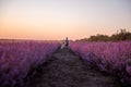 Playful cute boy girl are playing in rows of lavender purple field at sunset. Small couple. Allergy