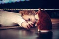Playful cute curious child pulling hand to toy under the bed in vintage style
