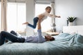 Playful dad have fun play with little daughter in bedroom