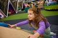 Playful excited girl child climbing rock at indoor playground Royalty Free Stock Photo