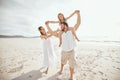 Playful family with adorable little daughter at the beach. Protective mom holding daughter on fathers shoulders Royalty Free Stock Photo