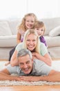 Playful family lying on each other in living room Royalty Free Stock Photo