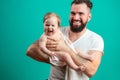 Playful father carrying his smiling infant child on neck over blue background Royalty Free Stock Photo